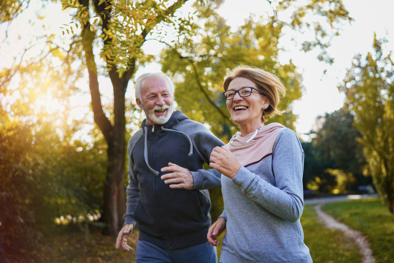 Cheerful active senior couple jogging in the park senior couple running